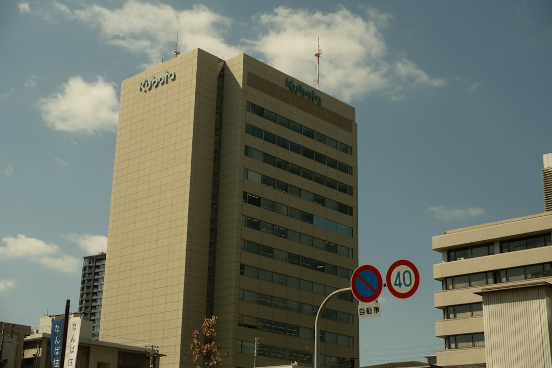Tall office building with blue sky and clouds.