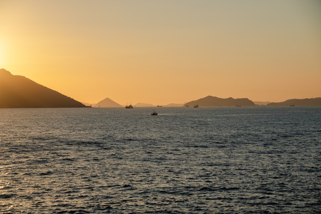 Sunset over the ocean with distant islands and boats