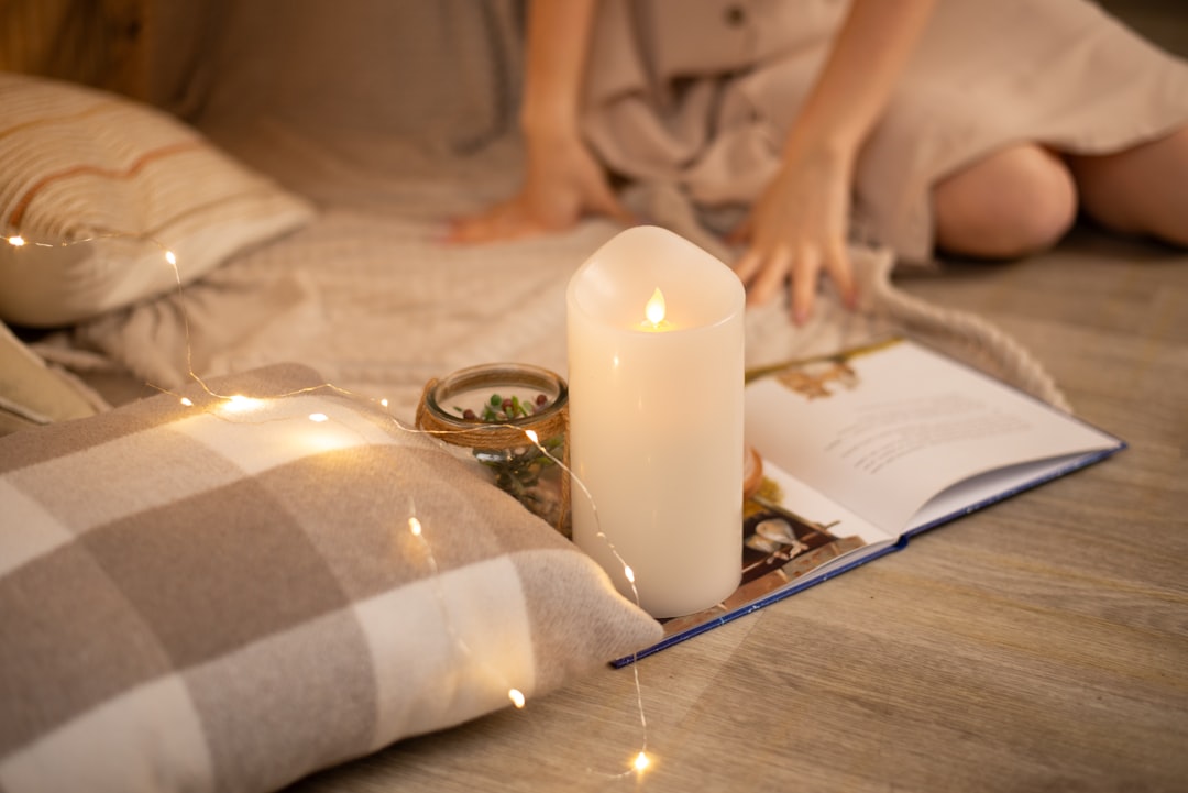 a candle and a book on a bed