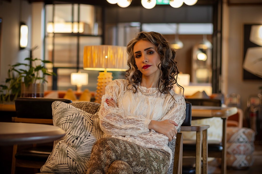 A woman sits confidently in a stylish interior.